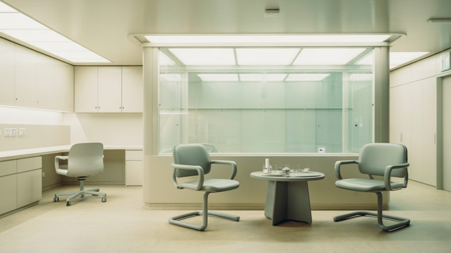Illustration : une salle d’entretien hospitalière vide, fauteuils disposés en cercle sous une lumière clinique