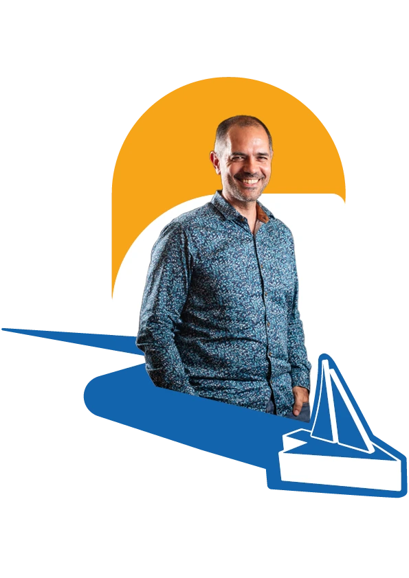 Portrait de Johan Theron, souriant, devant le voilier de son logo